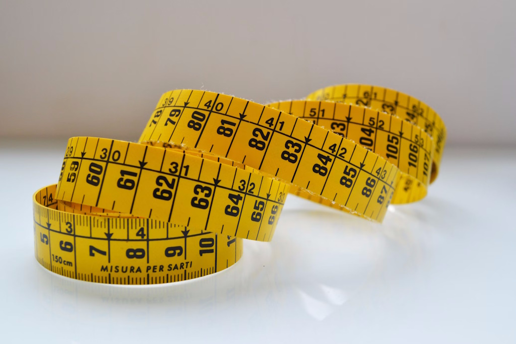 Yellow measuring tape on white background.